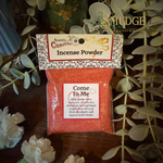 Bag of Aunty Conjure Incense Powder with decorative text on a wooden surface with greenery.