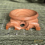 Wooden incense burner on a textured green surface with 'Smudge' branding.