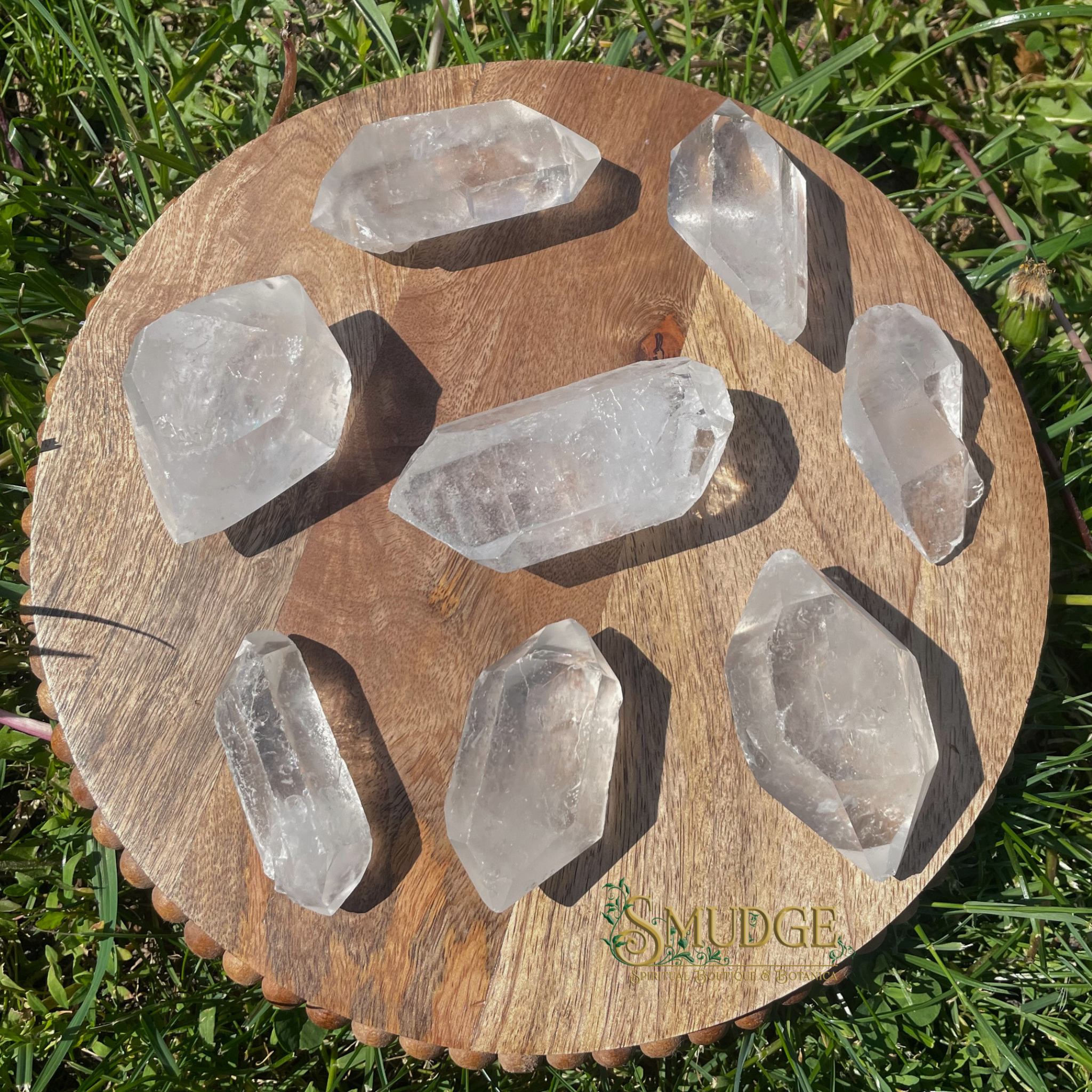 Wooden stand with clear crystal stones on a grassy background