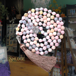 Necklace with multicolored beads and tassel on a blurred background with 'Smudge' brand visible