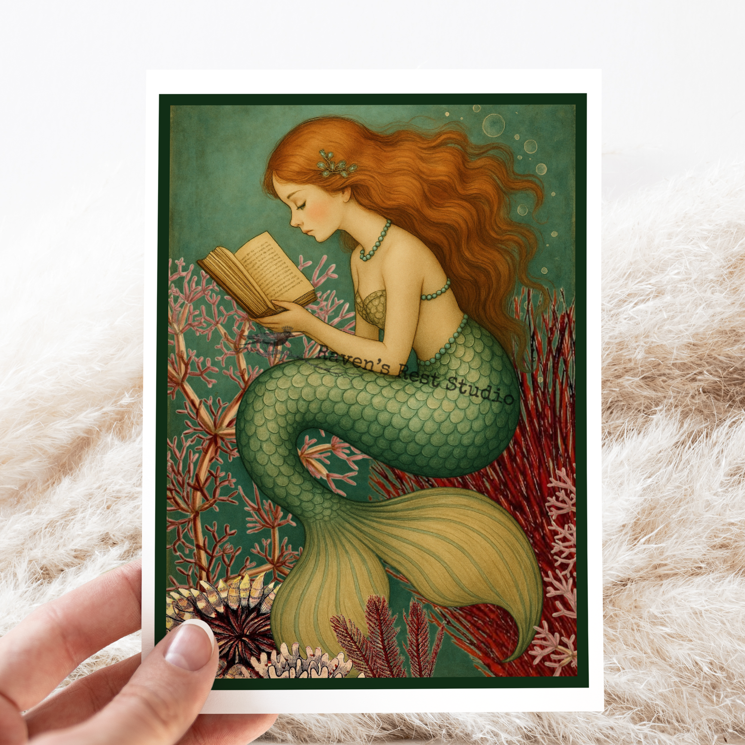 Mermaid reading a book with coral and sea life in the background, held against a textured surface.