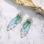 Green fairy wing earrings with silver accents and rainbow crystals on the wings.