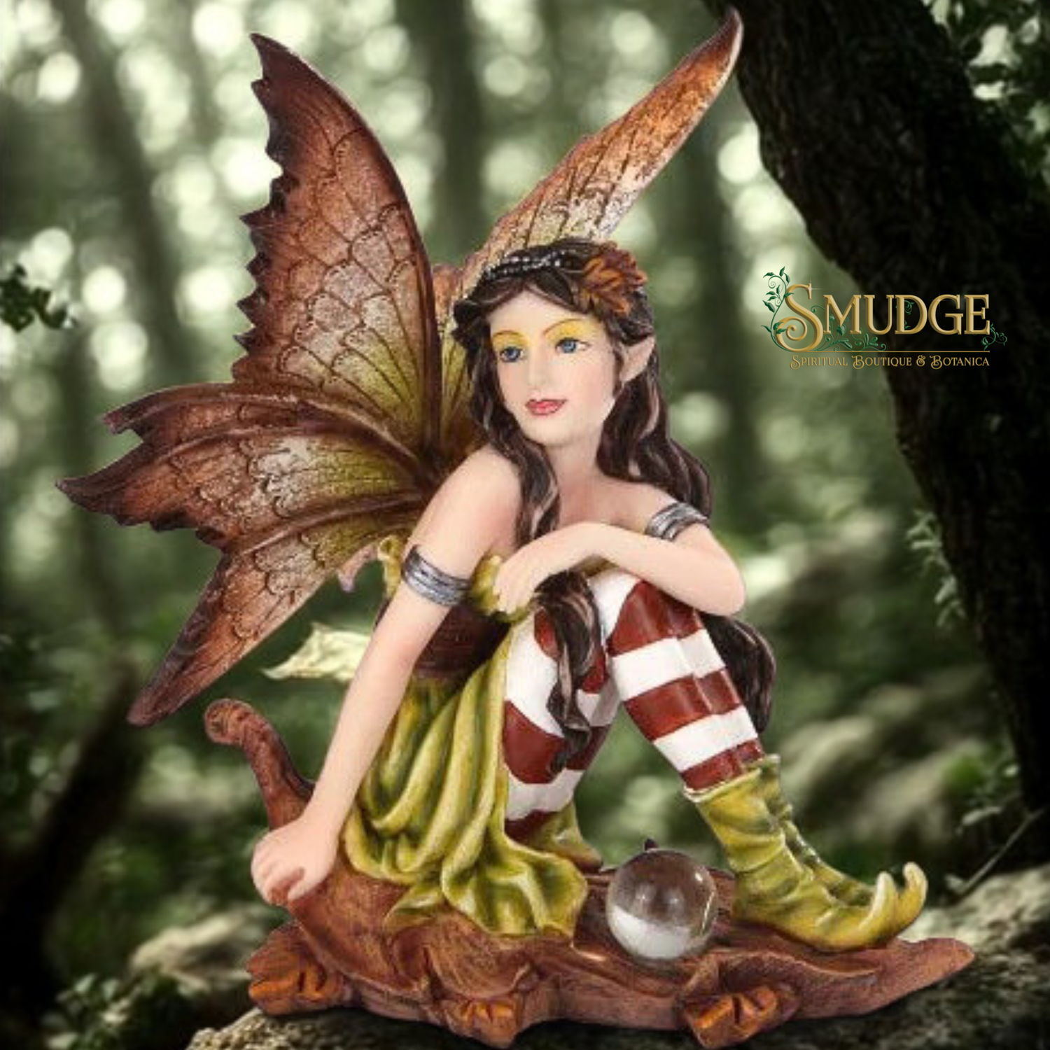 Fairy figurine with large wings and striped legs sitting on a rock in a forest setting, brand 'Smudge' visible.