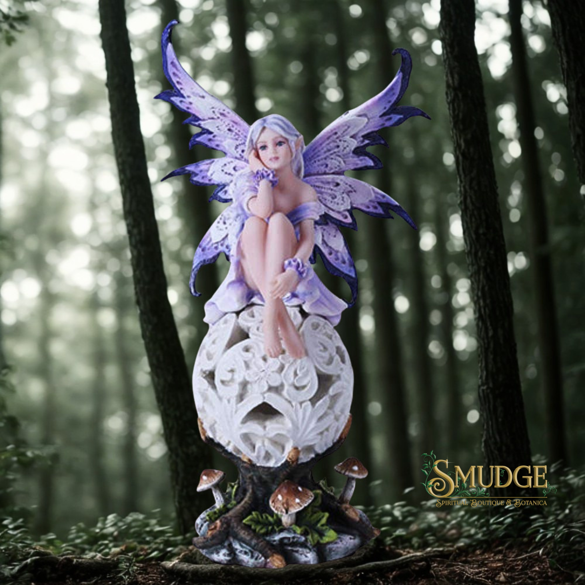 Fairy figurine with purple wings sitting on a decorative pedestal in a forest setting.