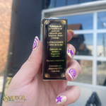 Hand holding a small black box with text, blurred background