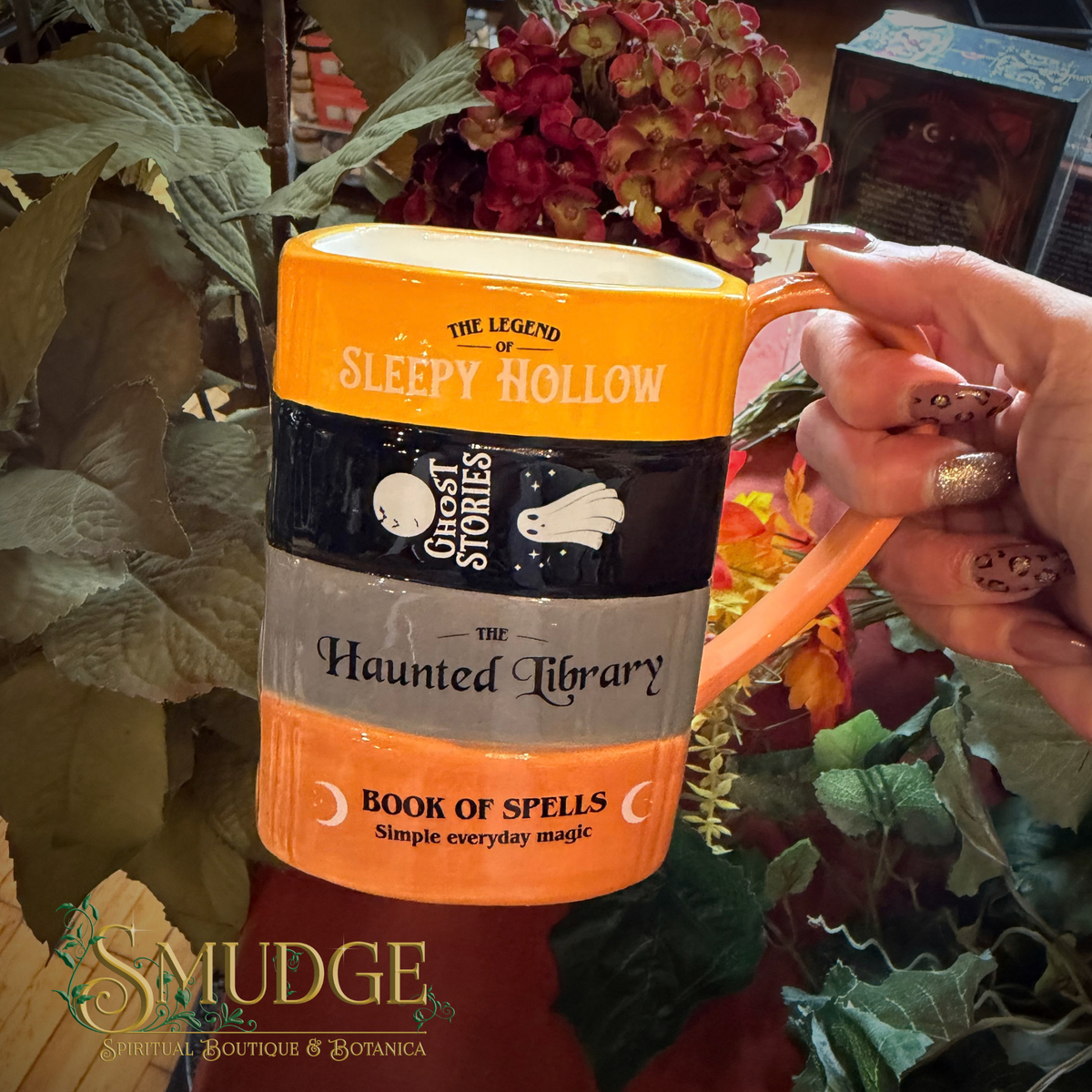 Haunted Library mug held by a hand