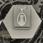 Silver pendant on a hexagonal gray stand with 'Smudge' branding.