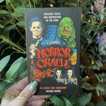 Classic Horror Oracle deck held in front of a green plant background