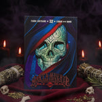 The deck box for 'Santa Muerte Book of the Dead' by Fabio Lustrn, featuring a detailed illustration of a skull under a red and blue veil, displayed on a red fabric surface with decorative flowers in the background.