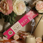 Box of Golden Nag Red Rose incense with flowers and a vase in the background