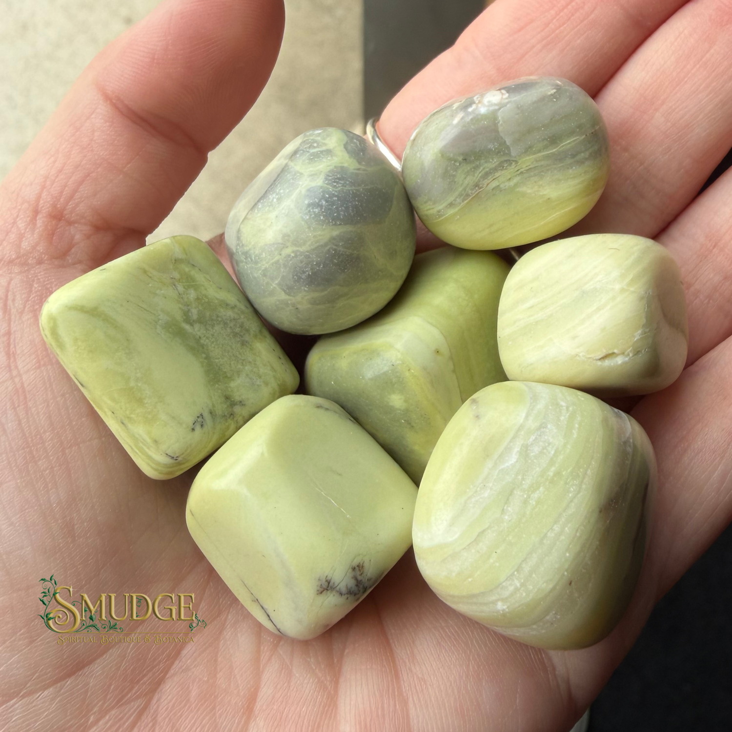 Lime green banded stones in hand with Smudge logo