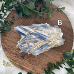 Crystal cluster on a wooden board with greenery around