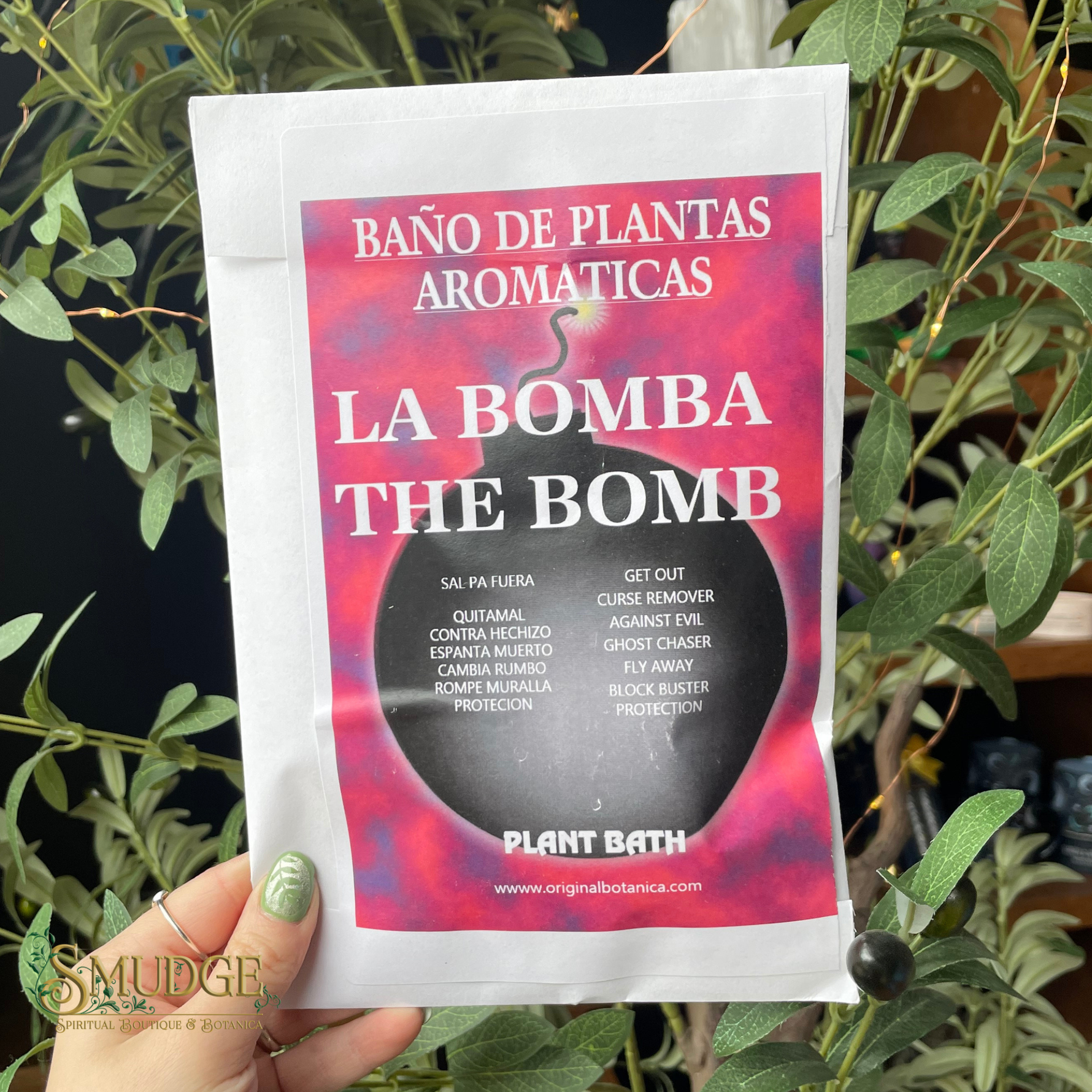 Product packaging labeled 'La Bomba The Bomb' held in front of green plants.