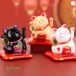 Three colorful cat figurines on a red background with 'Smudge' branding.