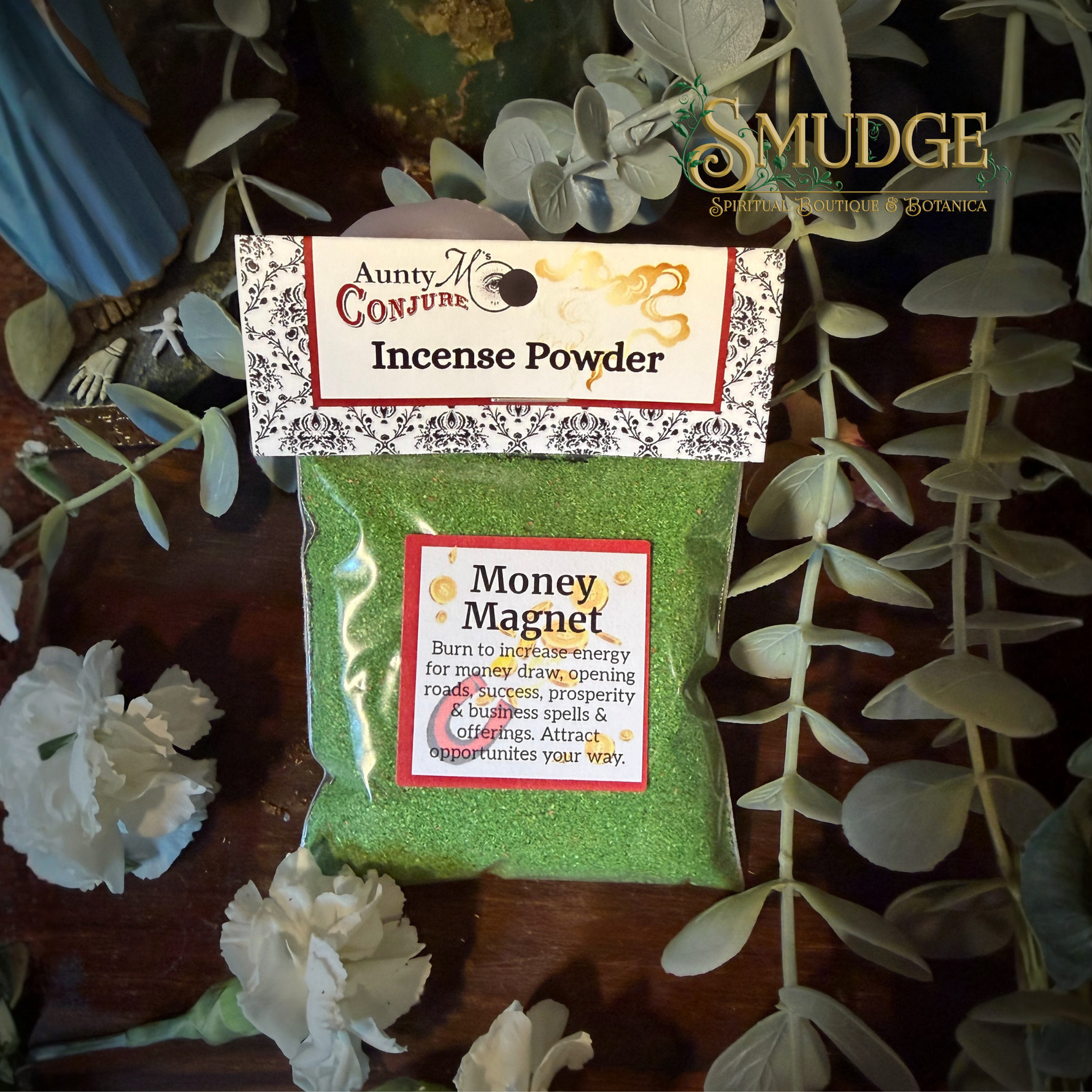 Pack of Aunty Conjure Incense Powder labeled 'Money Magnet' with decorative text on a wooden surface with greenery.
