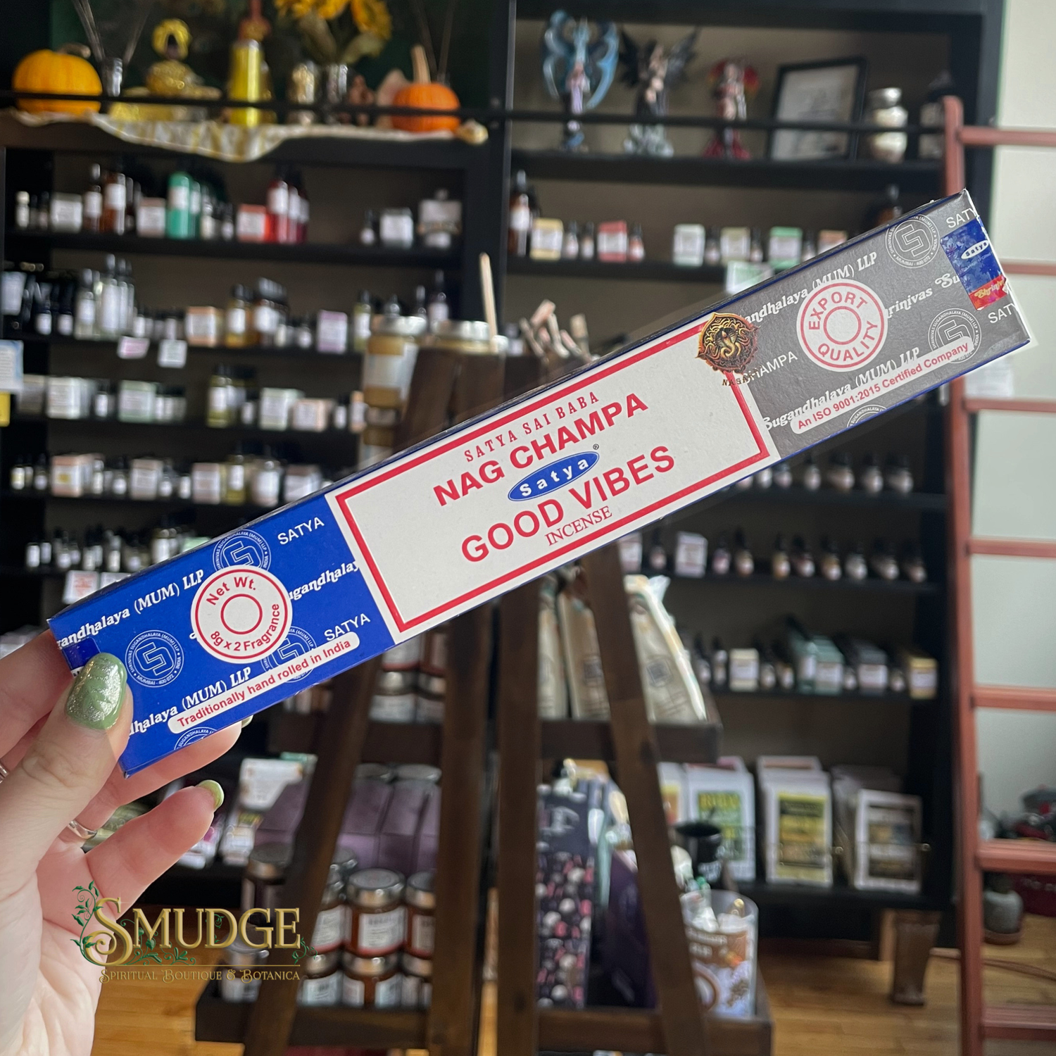Box of Satya Nag Champa Good Vibes incense held in front of a store shelf.
