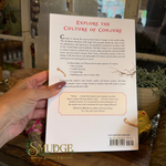 The back cover of the book 'Explore the Culture of Conjure' by Dr. Conjure, held by a hand.