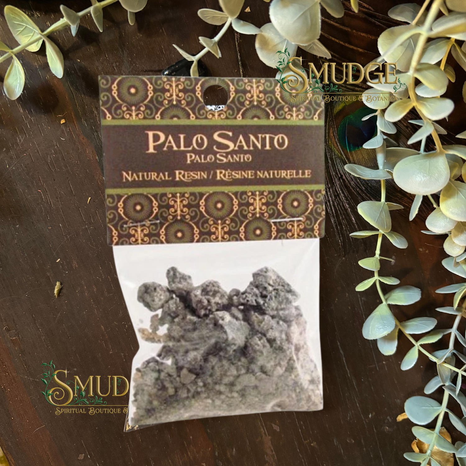 Palo Santo resin package with decorative label on a wooden surface with greenery.