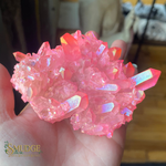 Pink crystal cluster held in a hand with 'Smudge' logo in corner