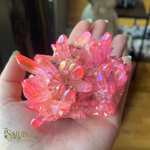 Pink crystal cluster held in a hand with 'Smudge' brand logo.