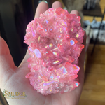 Pink crystal cluster held in a hand with 'SMUDGE' logo in the corner.