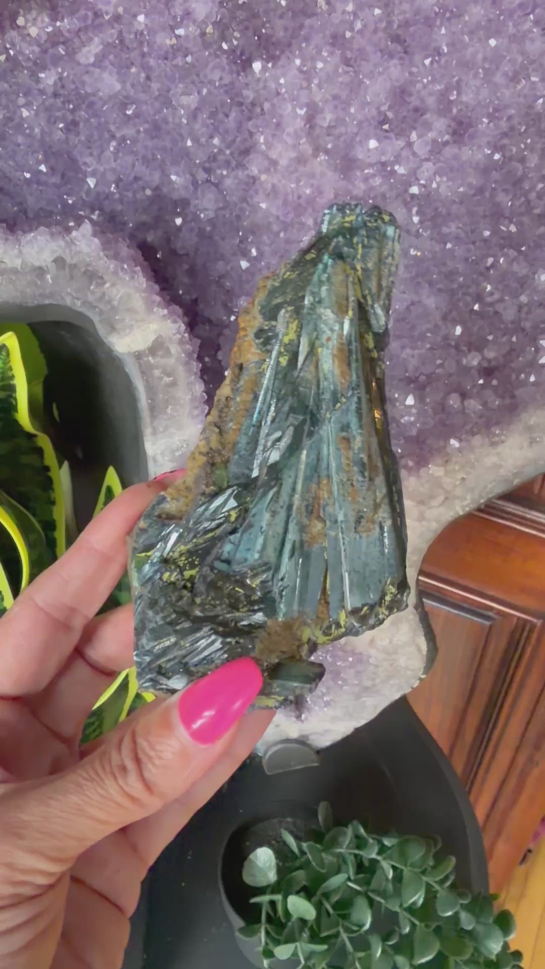Video of a green vivianite crystal being held by a hand, turning it in all directions.
