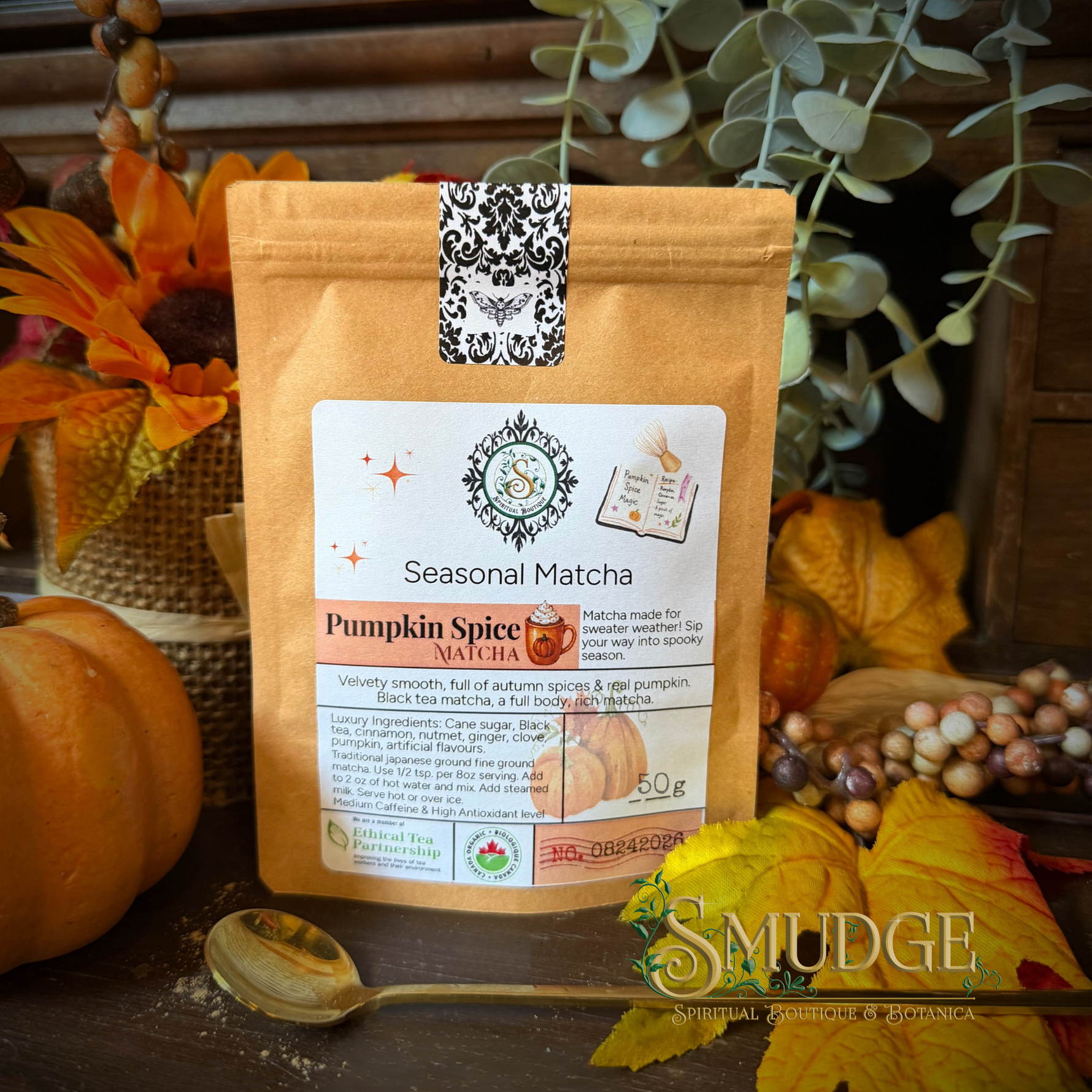A stand-up pouch of Smudge Seasonal Matcha Pumpkin Spice flavor, styled on a rustic wooden surface with autumn leaves, pumpkins, and eucalyptus branches.