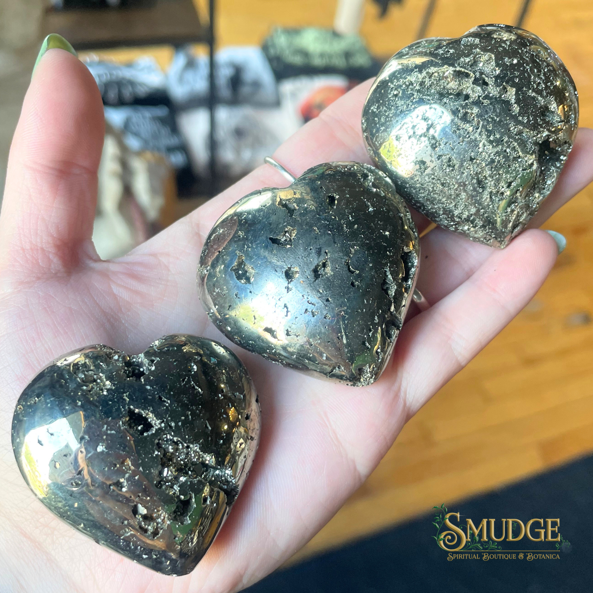 Three heart-shaped stones held in a hand with 'Smudge' brand logo in the corner.