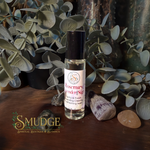 Roll-on bottle with label on a wooden surface with plants in the background, featuring the brand 'Smudge'.