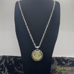 Silver chain necklace with a round pendant on a black mannequin bust.