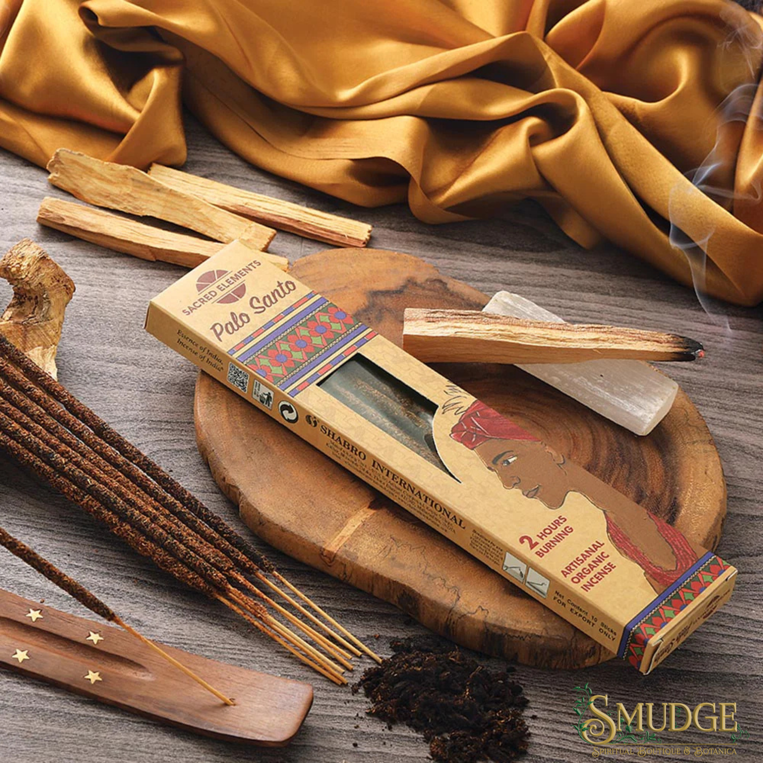 Palo Santo incense sticks with packaging on a wooden surface, surrounded by yellow fabric.