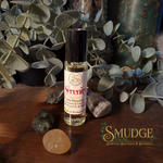 Roll-on bottle labeled 'Serenity' with decorative stones and plants on a wooden surface, featuring the brand 'Smudge'.