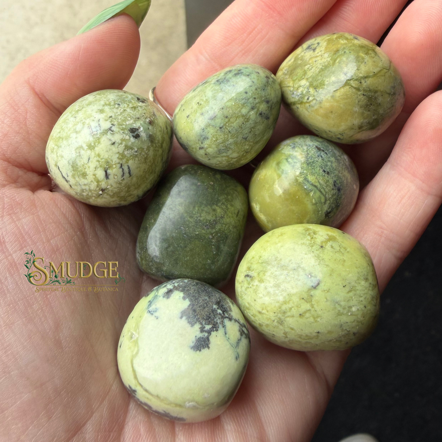 Green round stones held in a hand with Smudge logo