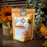A stand-up pouch of 'Sleepy Hollow Pumpkin Chai' seasonal tea by Smudge Spiritual Boutique & Botanica, styled on a rustic wooden surface with autumn props including a sunflower, pinecone, and eucalyptus leaves.
