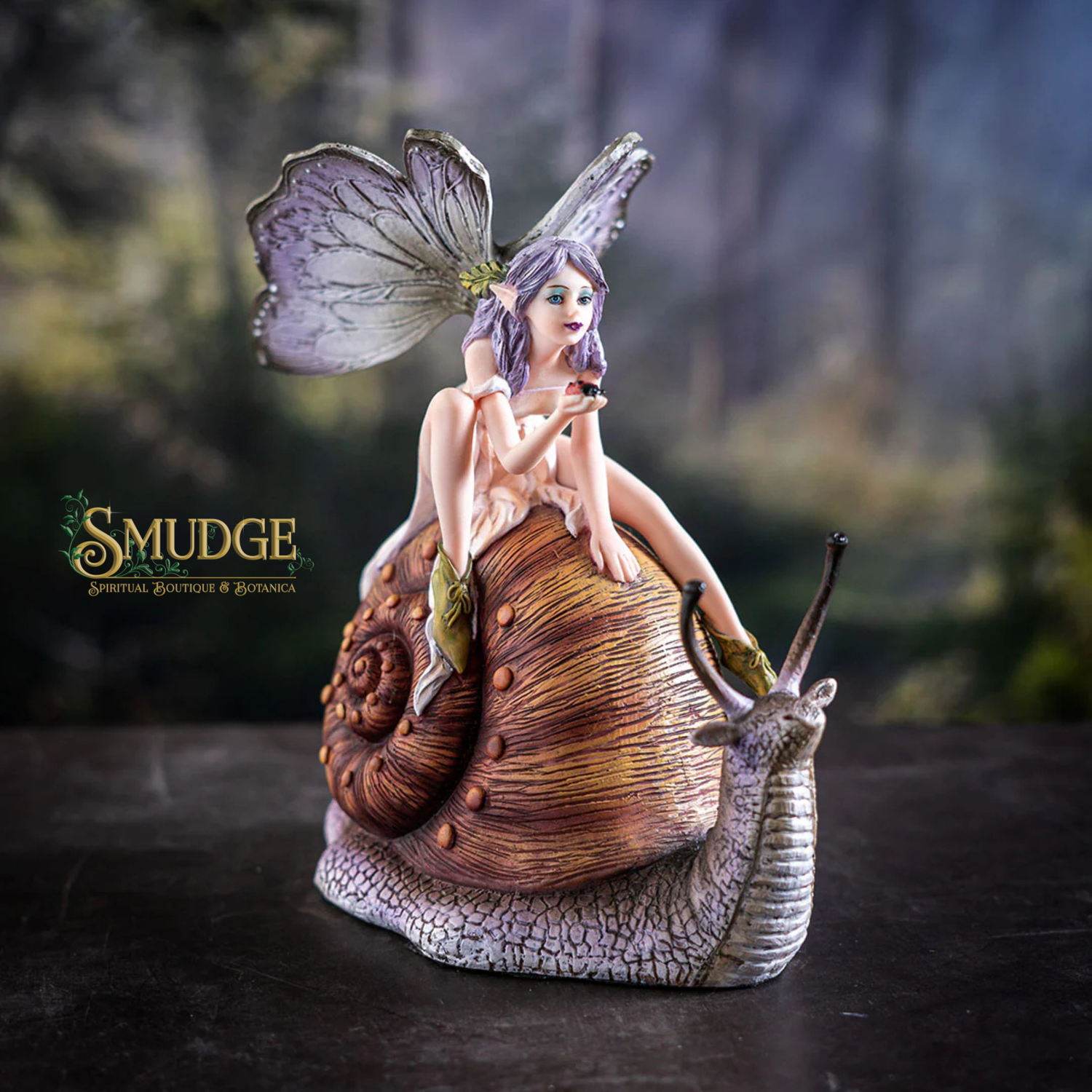 Fairy figurine with butterfly wings sitting on a snail, brand 'Smudge' visible