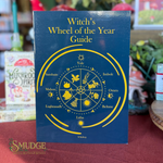 A book titled 'Witch's Wheel of the Year Guide' by S. Sobry, featuring a dark blue cover with a yellow astrological wheel diagram.