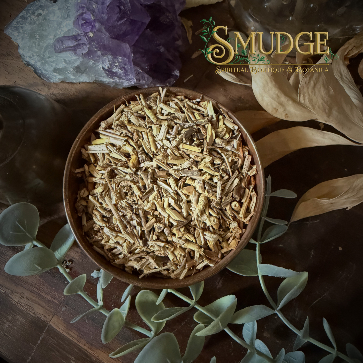 Wooden bowl with dried herbs on a wooden surface with 'Smudge' branding.