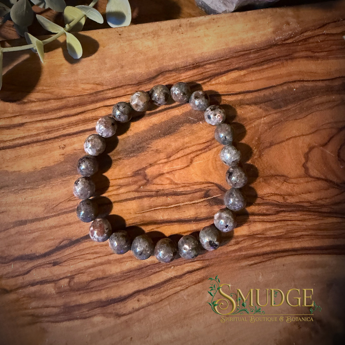 8mm yooperlite crystal bracelet on a wooden background.