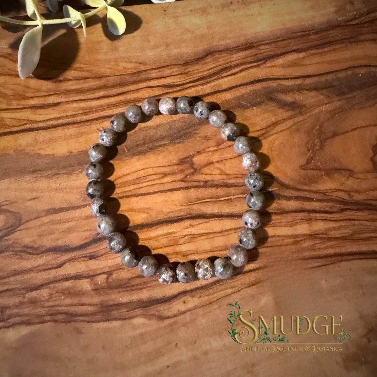 6mm yooperlite crystal bracelet on a wooden background.